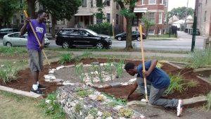 Two volunteers from After School Matters perfect the drainage area