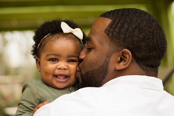 African American loving father holding his daughter.