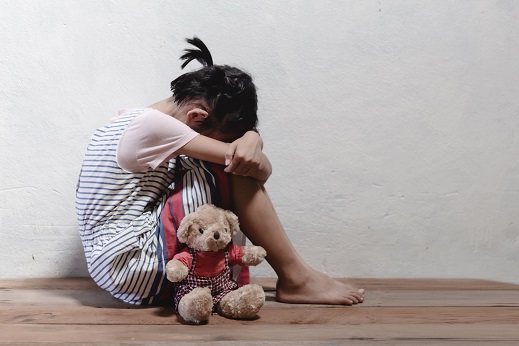 traumatized children concept. little girl sitting at the corner of the room feeling sad and lonely.