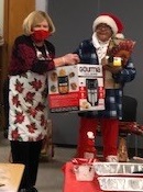 A class participant receives an air fryer from Linda, left, during the nutrition class holiday gathering.