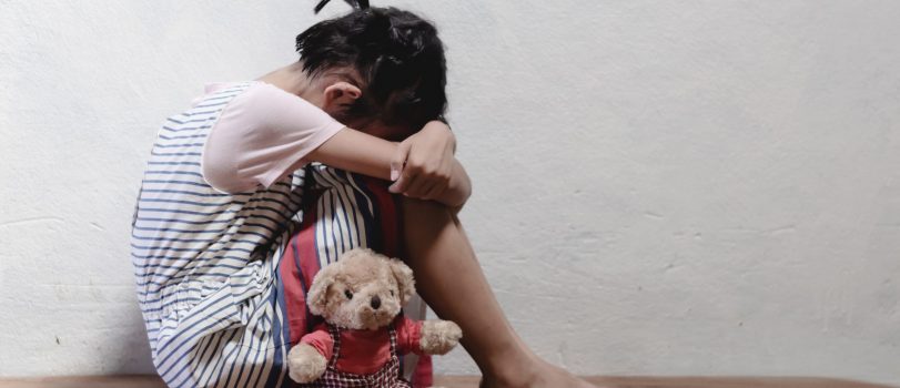 traumatized children concept. little girl sitting at the corner of the room feeling sad and lonely.