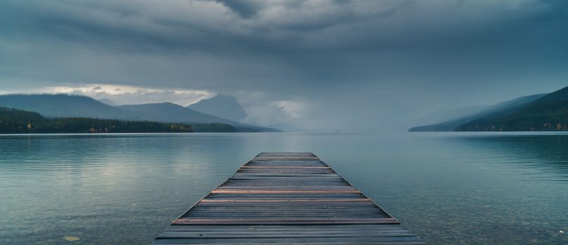 Dock overlooking a calm overcast lake.